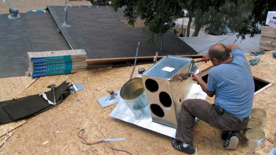 guy on roof installing A/C unit